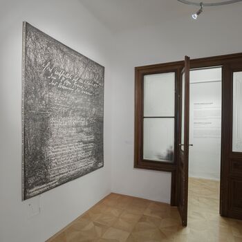 Ein Ausstellungsraum mit einer Kunstinstallation und zwei offenen Flügeltüren