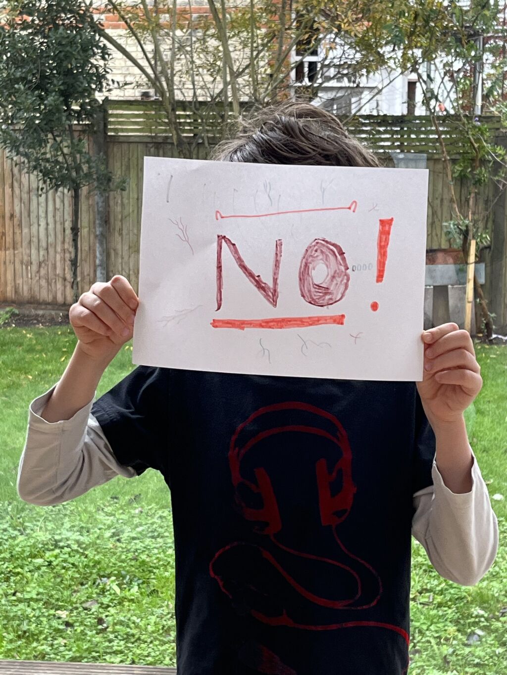 Eine Person zeigt ein Blatt Papier mit dem Wort NO!
