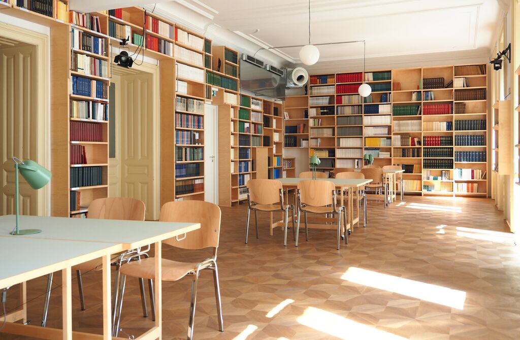 Ein Foto mehrerer Bücherregale, Tische und Stühle