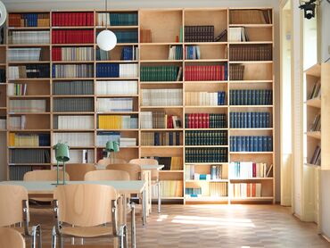 A photo of several bookshelves, tables, and chairs
