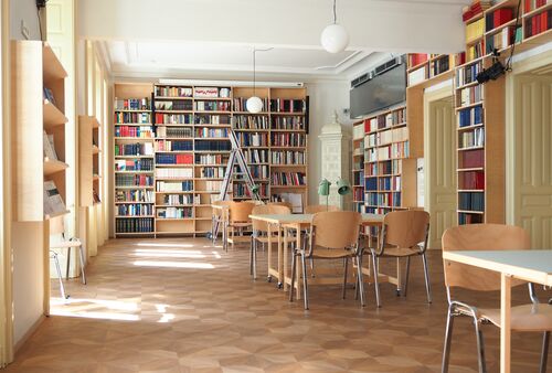 Ein Foto mehrerer Bücherregale, Tische und Stühle
