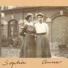 A black-and-white photograph: two women standing.